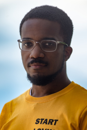 photo of Black man with glasses and yellow shirt